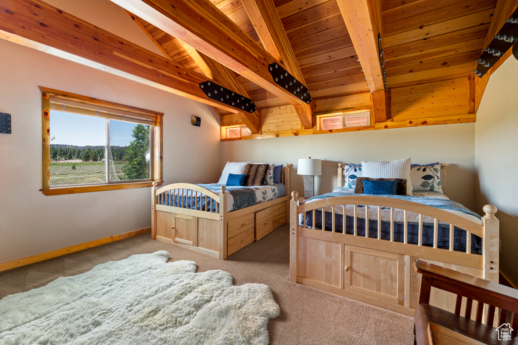 Bedroom featuring lofted ceiling with beams, light carpet, and wooden ceiling