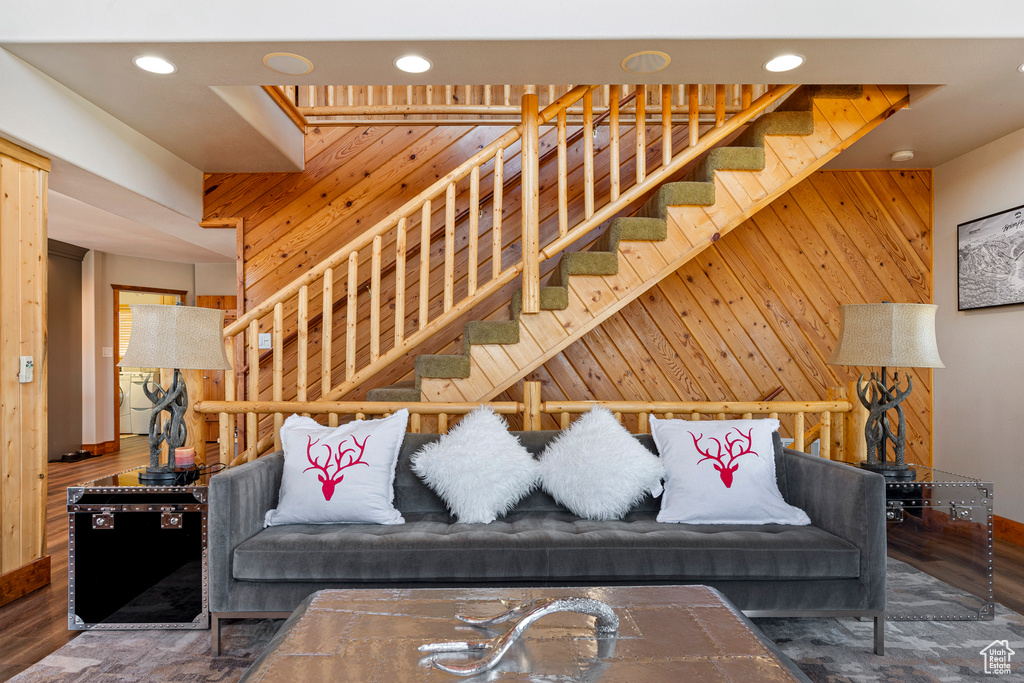 Living room featuring dark hardwood / wood-style floors and wooden walls