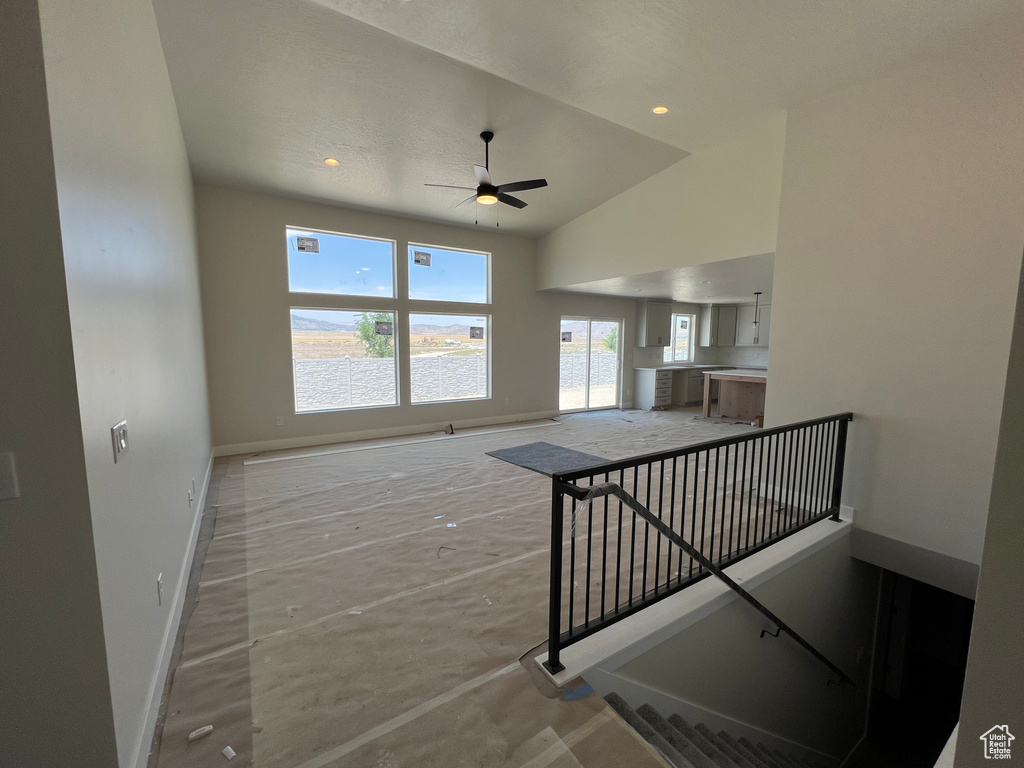 Staircase featuring ceiling fan and vaulted ceiling