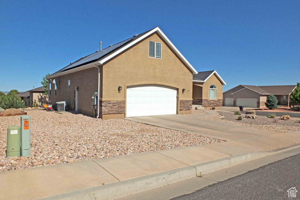 View of front facade with a garage and central AC unit