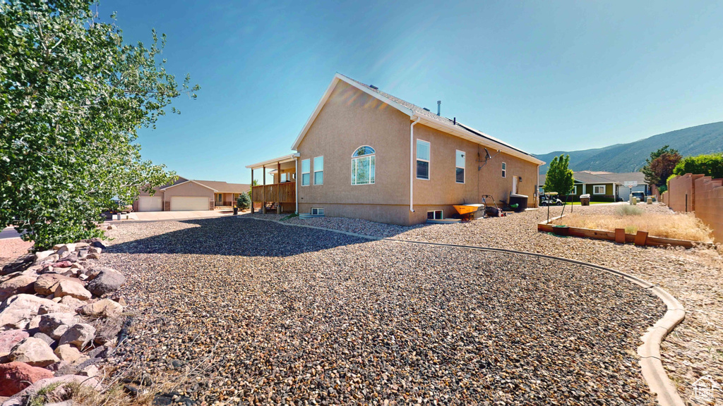 View of property exterior with a garage and a mountain view