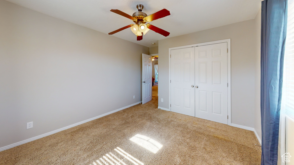 Unfurnished bedroom featuring ceiling fan, a closet, and carpet flooring