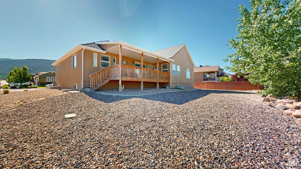 Back of property featuring a deck with mountain view