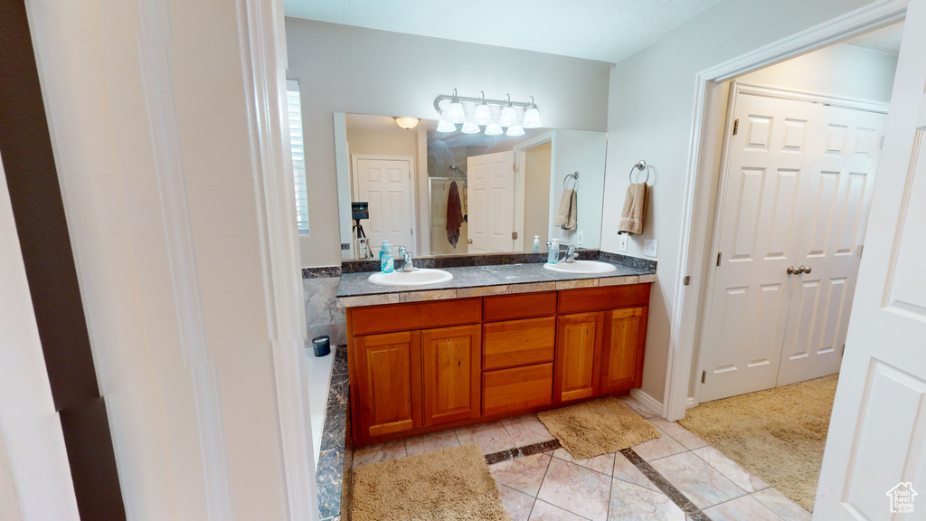 Bathroom with dual bowl vanity and tile flooring