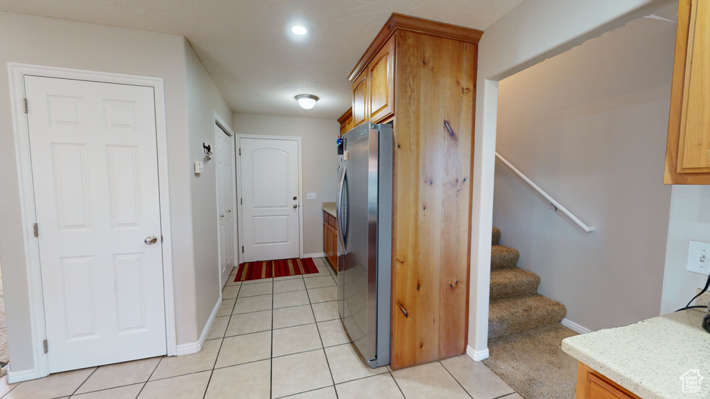 Kitchen featuring stainless steel fridge and light tile floors