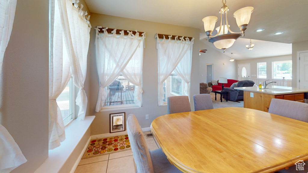 Dining room with sink, a chandelier, and light tile floors