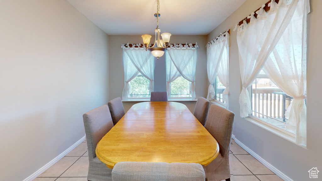 Tiled dining room featuring a notable chandelier