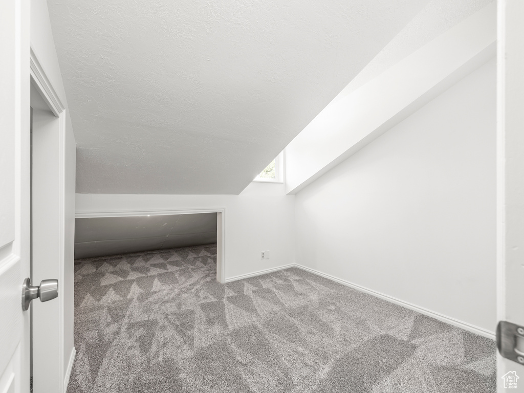 Bonus room featuring vaulted ceiling and carpet floors