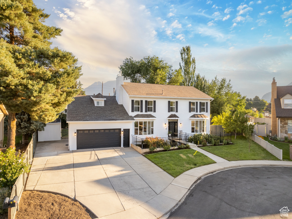 View of front facade featuring a front yard and a garage