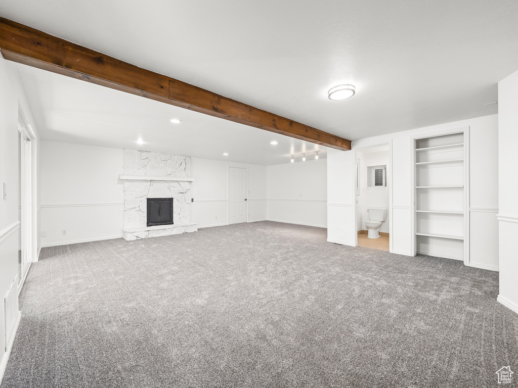 Basement featuring a stone fireplace and carpet floors