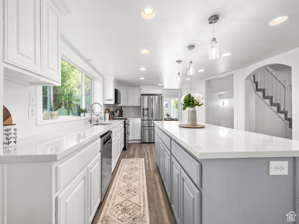 Kitchen featuring a center island, sink, backsplash, and dark hardwood / wood-style floors