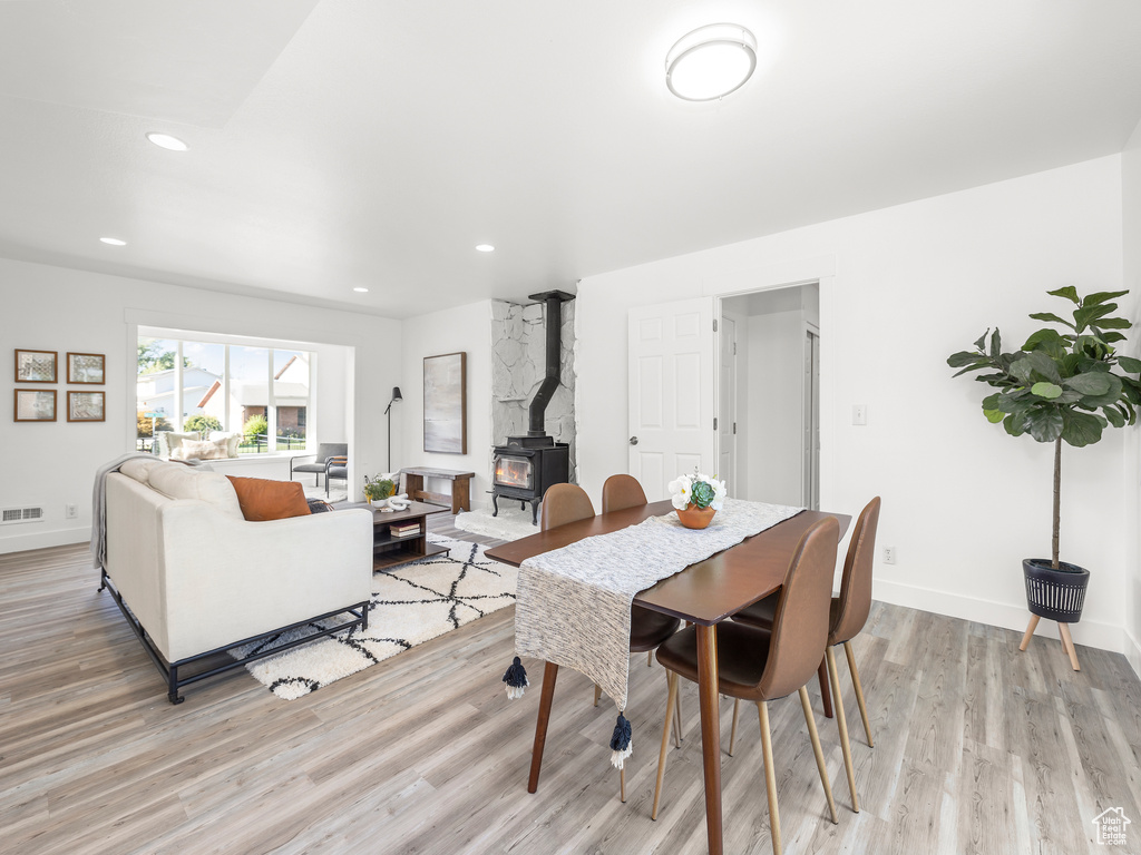 Dining space featuring light hardwood / wood-style floors and a wood stove