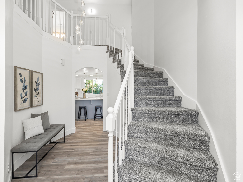 Stairway with a high ceiling and hardwood / wood-style flooring