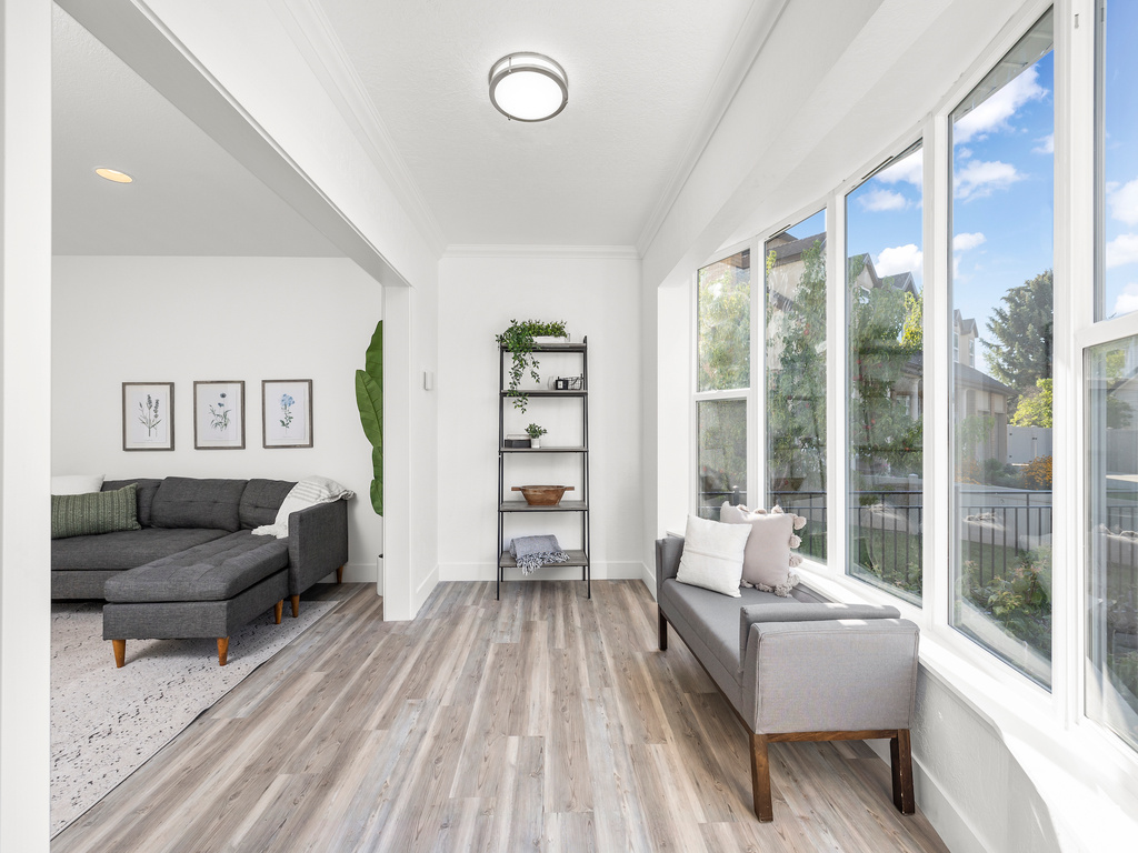 Living area with light hardwood / wood-style floors and crown molding