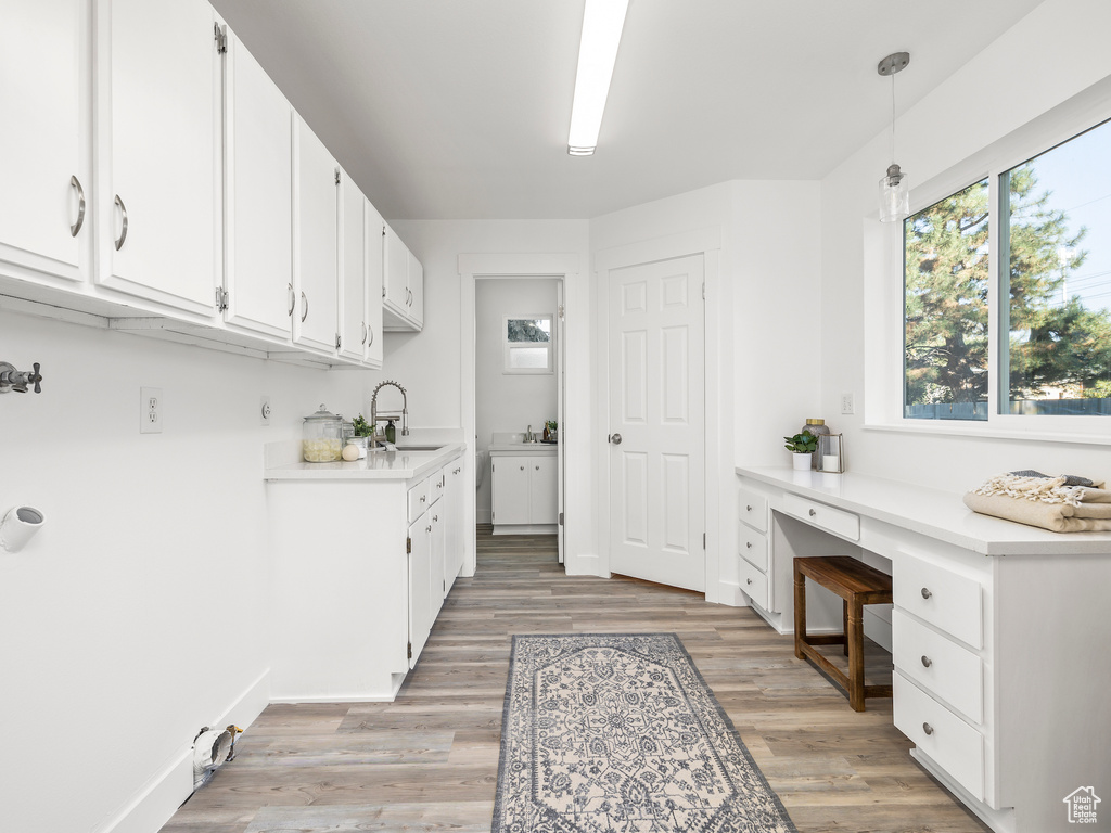 Laundry room featuring sink and light hardwood / wood-style flooring