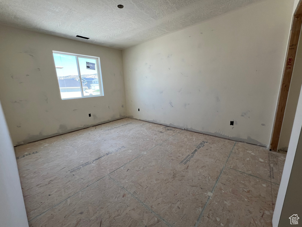 Unfurnished room featuring a textured ceiling