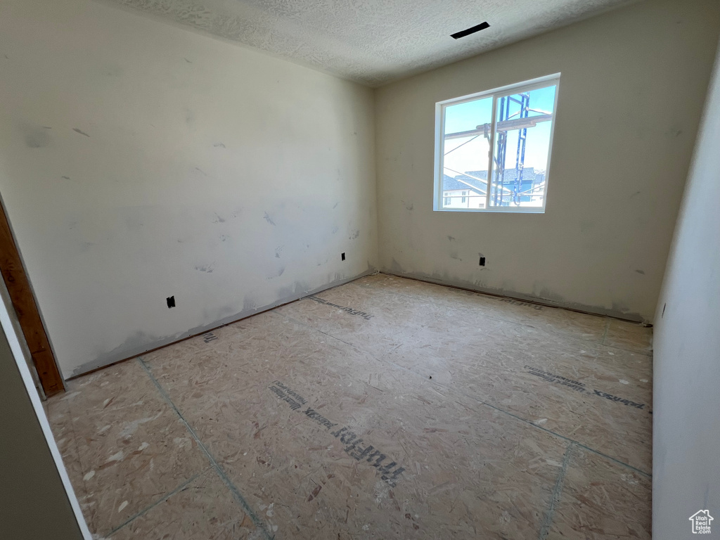 Unfurnished room featuring a textured ceiling