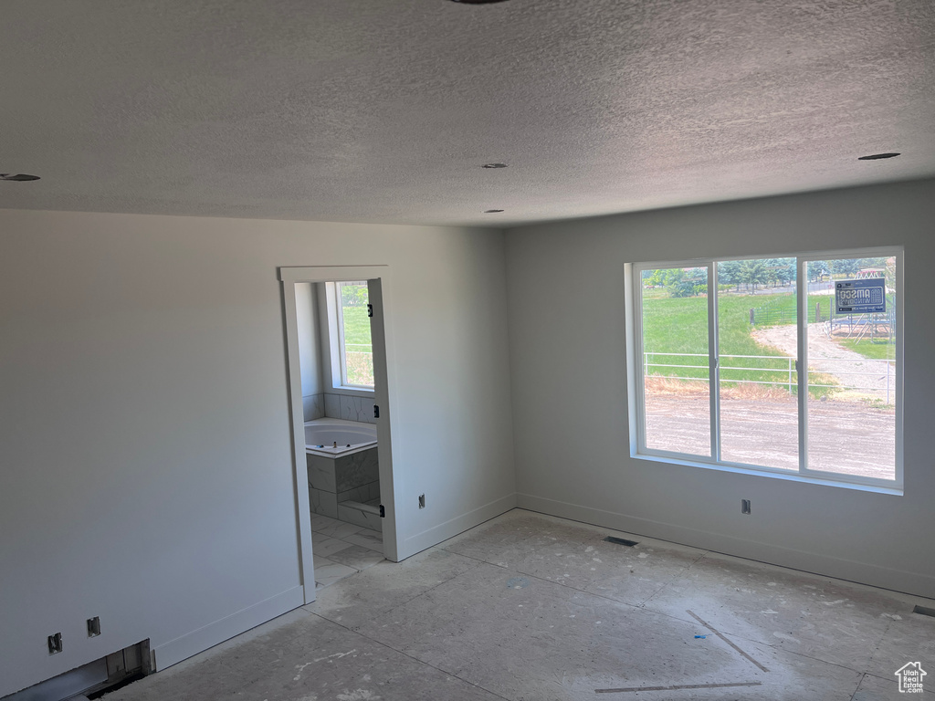 Spare room with a healthy amount of sunlight and a textured ceiling