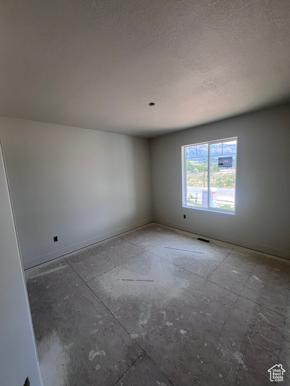 Unfurnished room featuring a textured ceiling