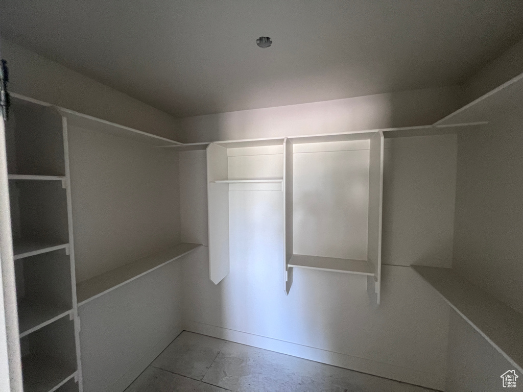 Walk in closet with tile flooring