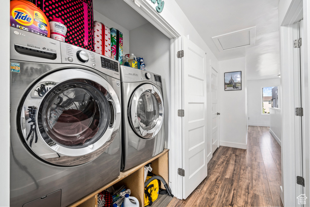 Washroom featuring dark hardwood / wood-style flooring and washing machine and clothes dryer