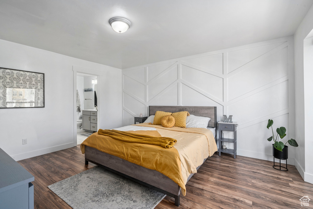 Bedroom featuring ensuite bath and dark wood-type flooring