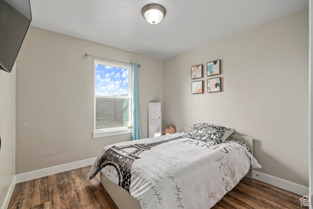 Bedroom with dark hardwood / wood-style flooring