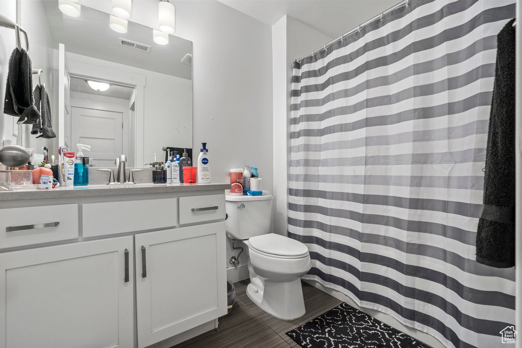 Bathroom with tile floors, large vanity, and toilet