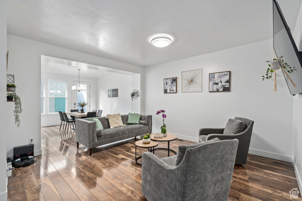 Living room with a notable chandelier and dark wood-type flooring