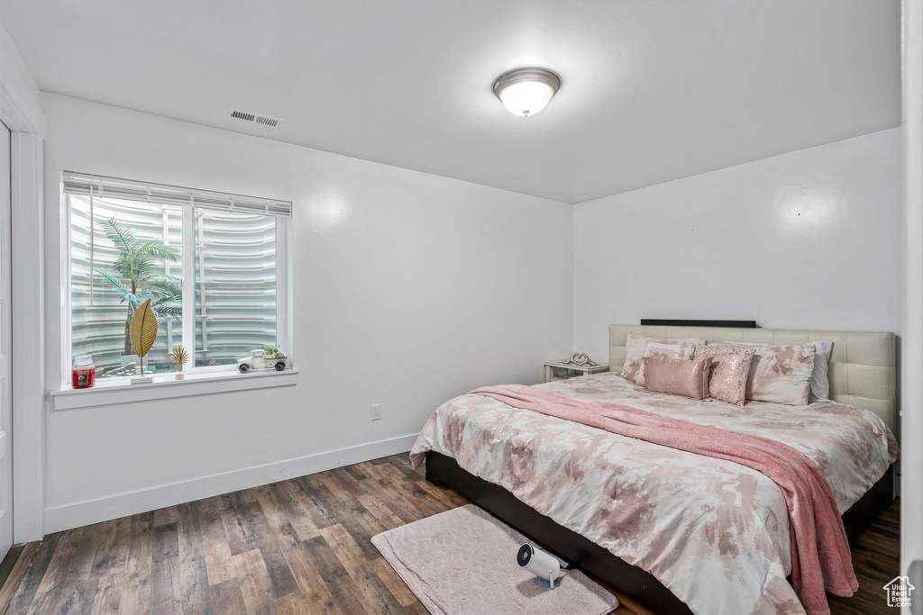 Bedroom with dark hardwood / wood-style flooring