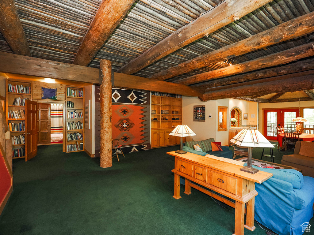 Living room featuring beamed ceiling, built in features, and carpet