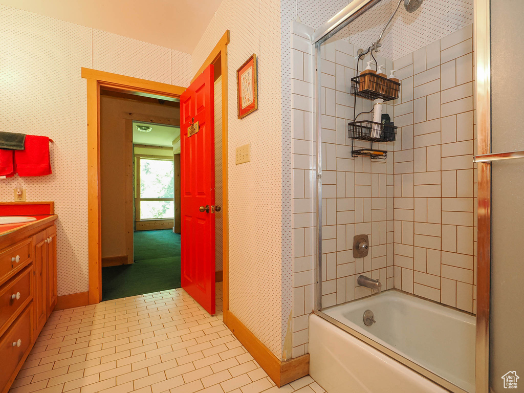 Bathroom with tile flooring, vanity, and enclosed tub / shower combo