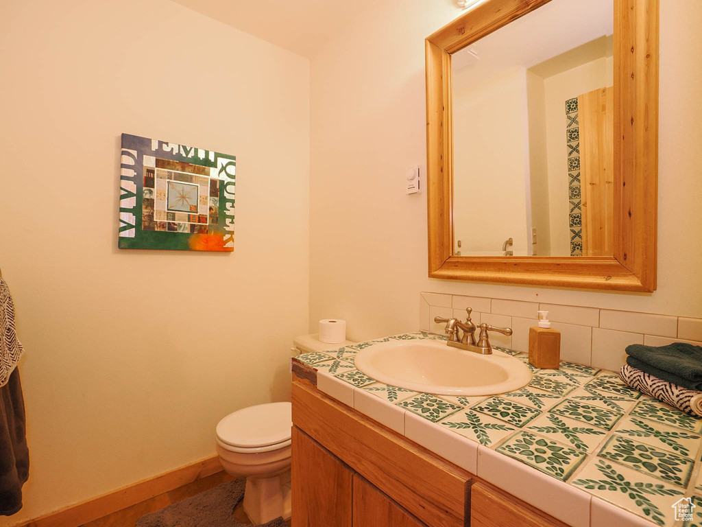 Bathroom with backsplash, vanity, and toilet