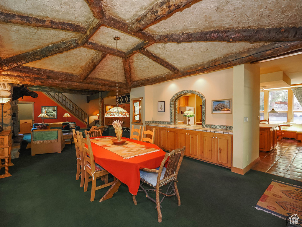 Dining space featuring beamed ceiling, coffered ceiling, and carpet floors