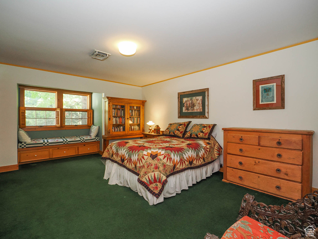 Bedroom featuring ornamental molding and dark carpet