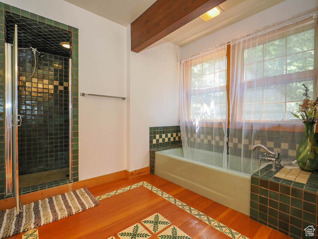 Interior space with beam ceiling and hardwood / wood-style flooring