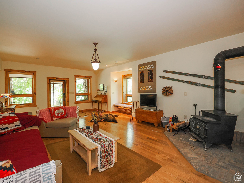 Living room with a wealth of natural light, a wood stove, and hardwood / wood-style floors