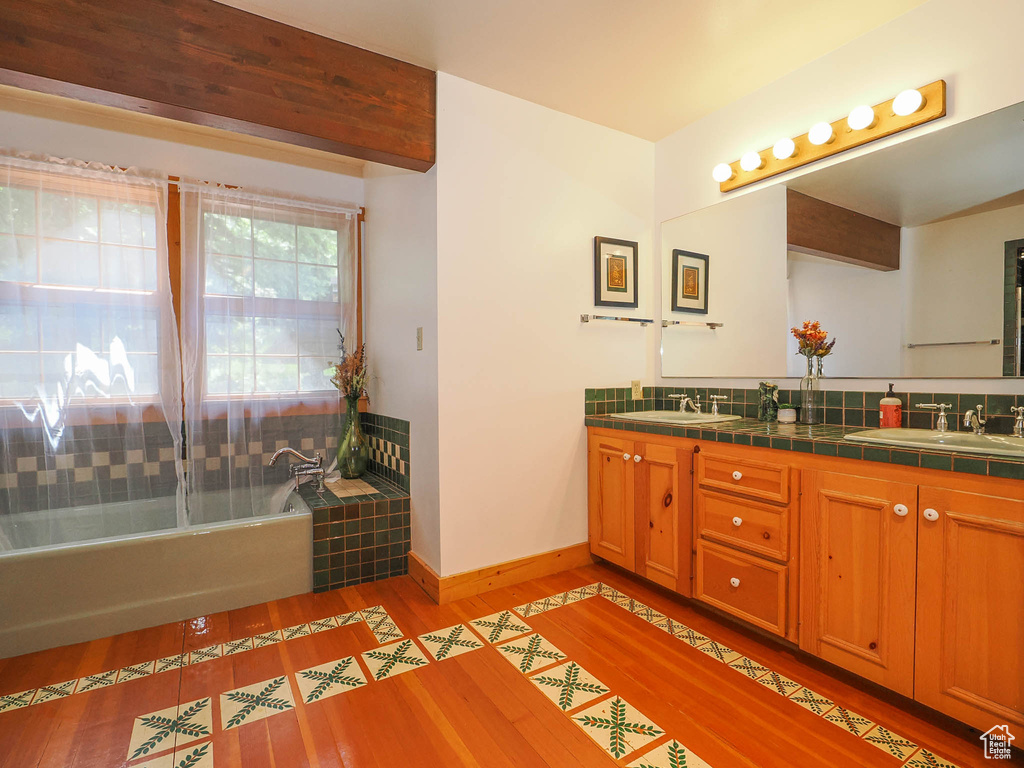 Bathroom with double vanity and hardwood / wood-style flooring