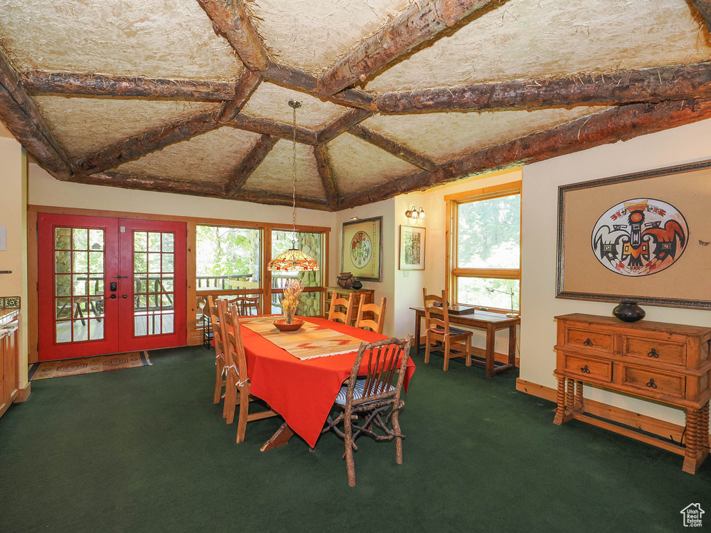 Carpeted dining area with coffered ceiling, beam ceiling, and french doors