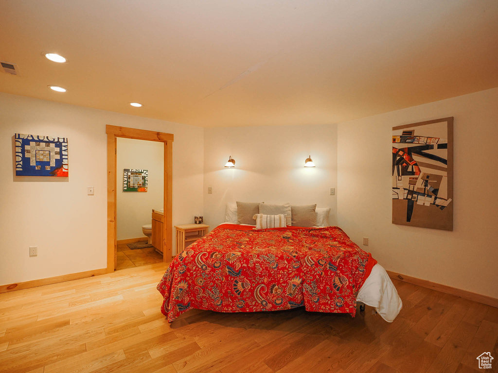 Bedroom featuring connected bathroom and light wood-type flooring