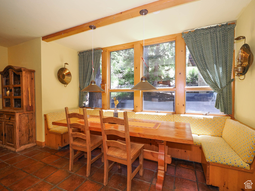 Tiled dining room with beam ceiling