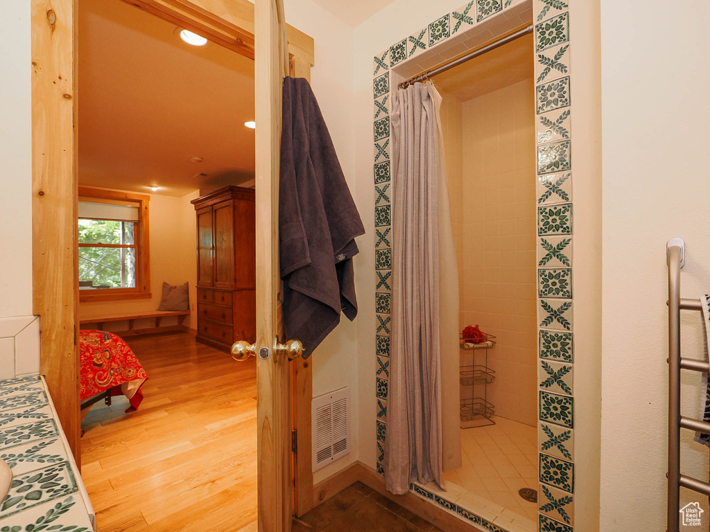 Bathroom with walk in shower and hardwood / wood-style flooring