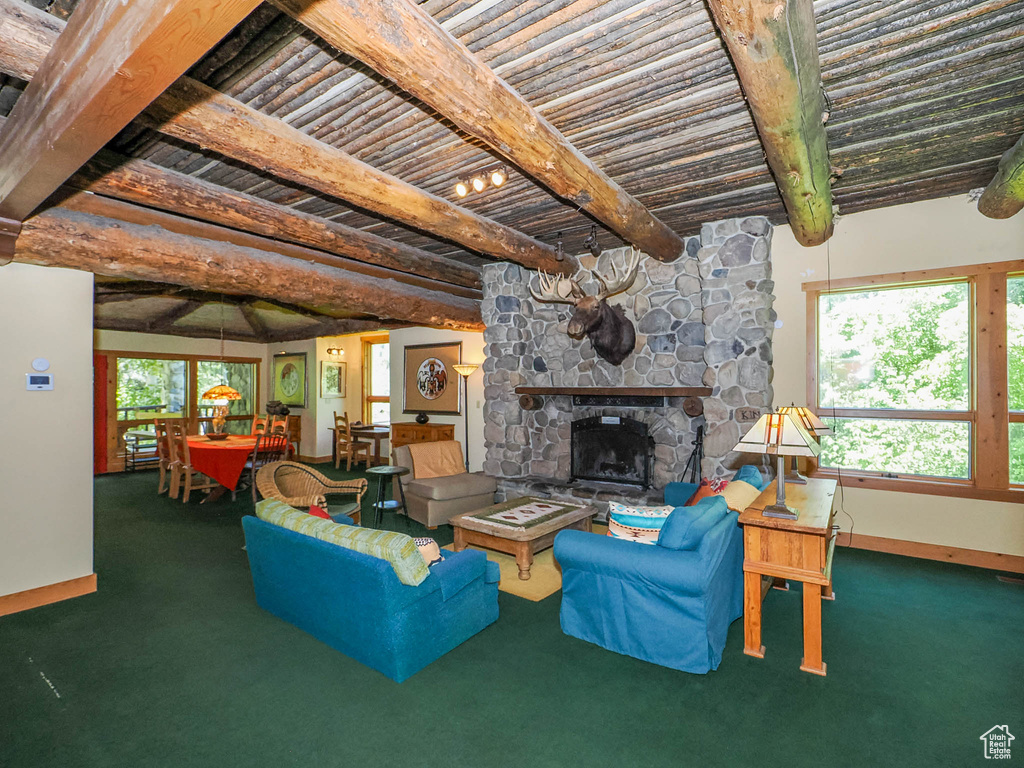 Unfurnished living room with carpet, beam ceiling, and a fireplace