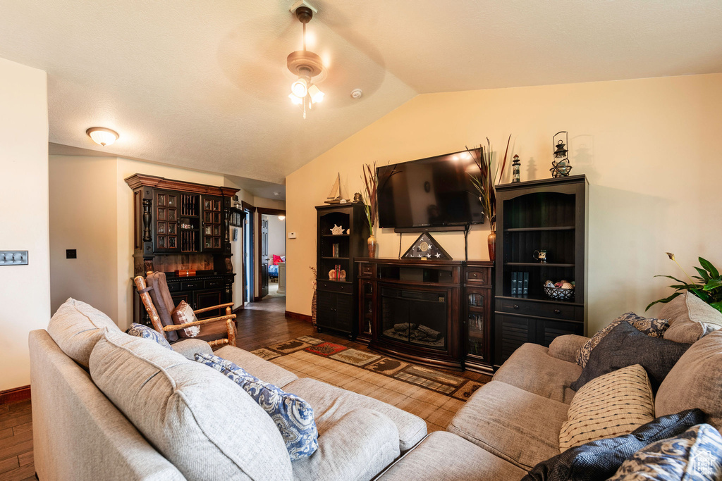 Living room with hardwood / wood-style flooring, lofted ceiling, and ceiling fan