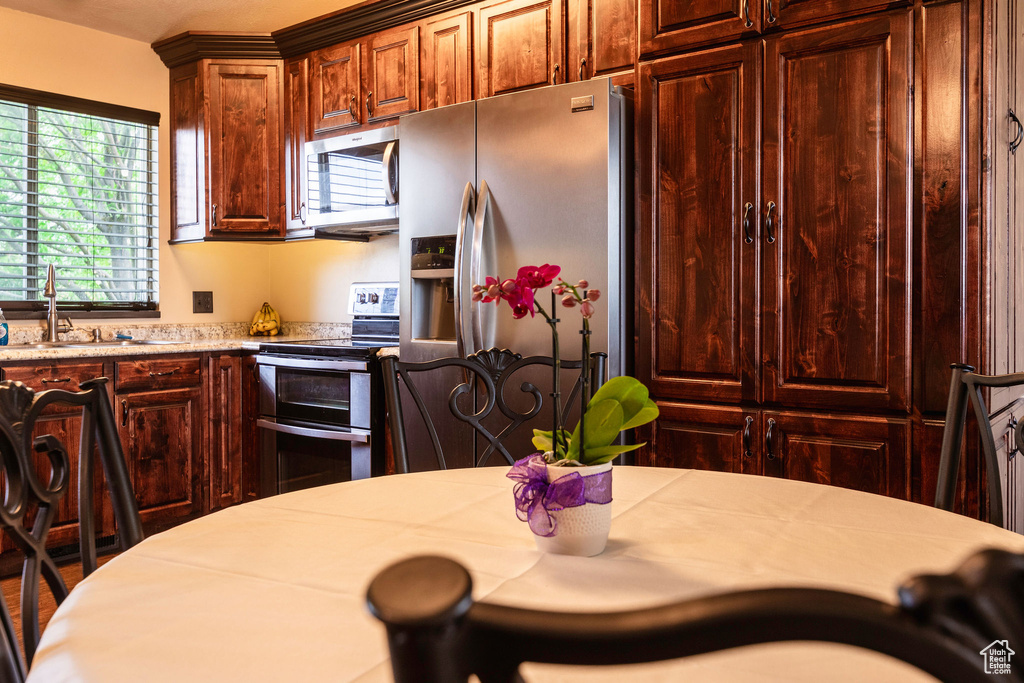 Kitchen with light stone countertops, stainless steel appliances, and sink