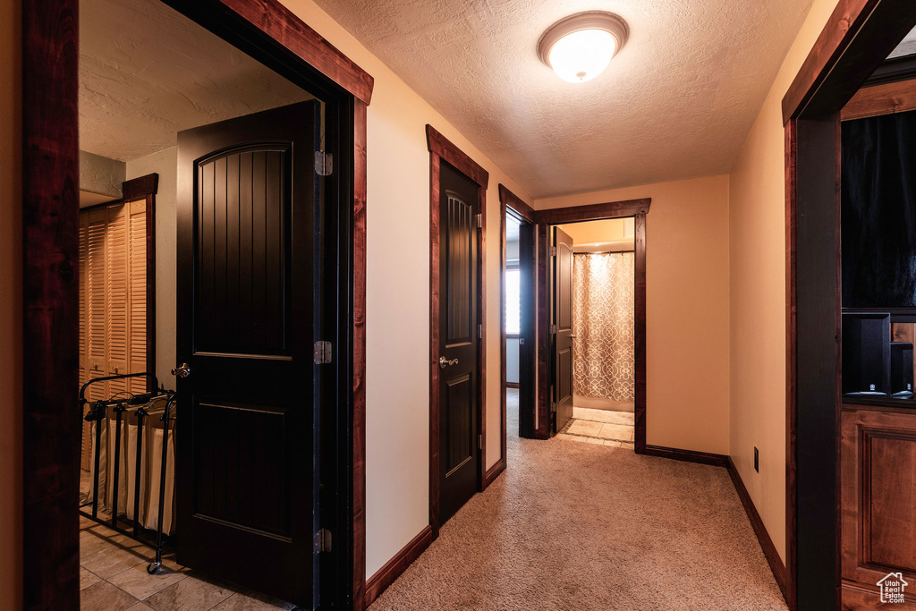 Hall with a textured ceiling and light carpet