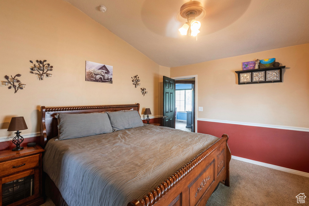 Carpeted bedroom with lofted ceiling and ceiling fan