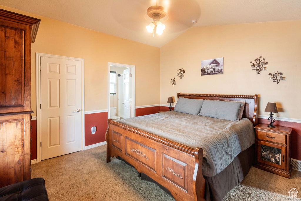 Bedroom with ensuite bath, ceiling fan, lofted ceiling, and carpet flooring