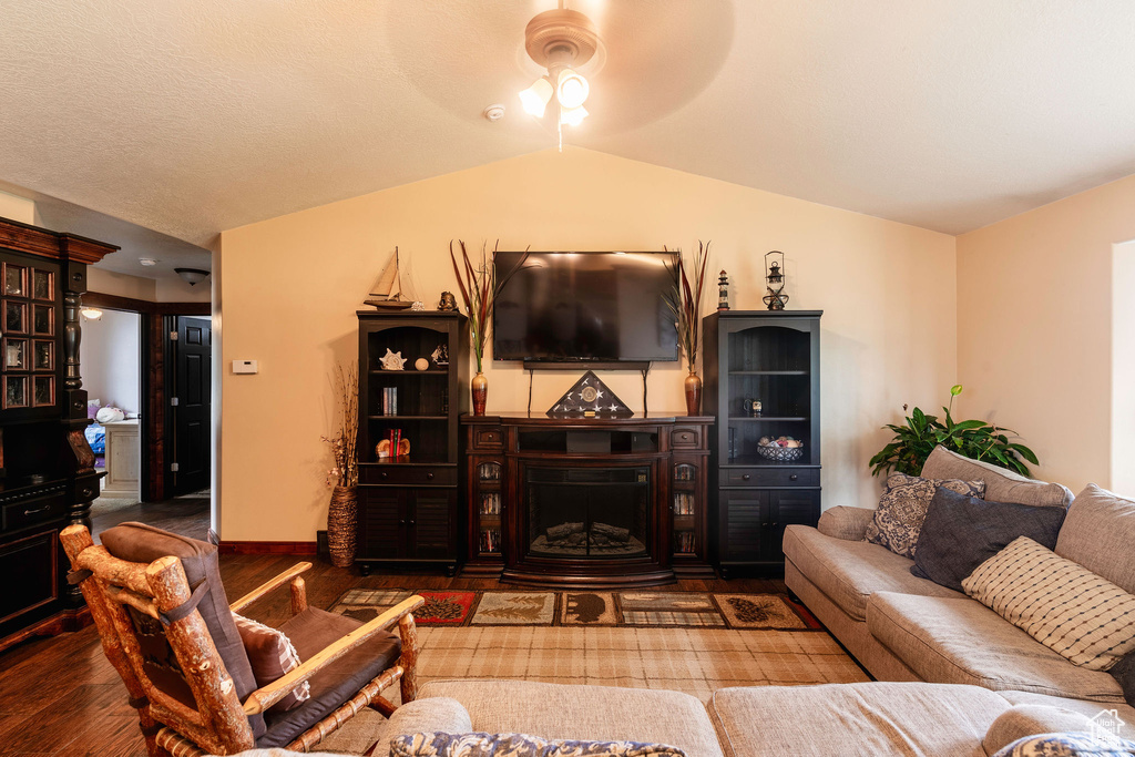 Living room with ceiling fan, hardwood / wood-style floors, and lofted ceiling