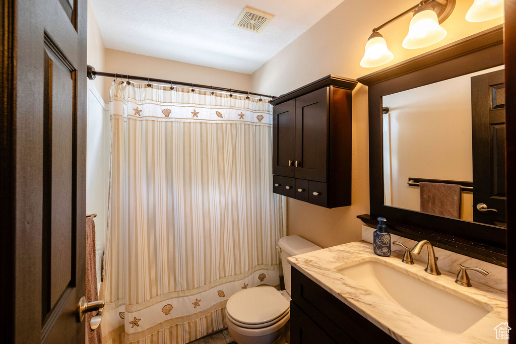 Full bathroom with vanity, toilet, and shower / tub combo with curtain